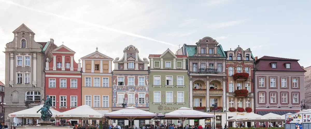 Kolorowe kamienice na Starym Rynku w Poznaniu, fontanna i ogródki kawiarni