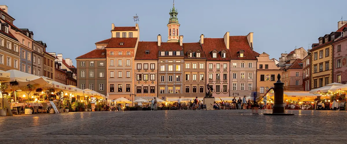 Rynek Starego Miasta w Warszawie o zmierzchu, ogródki kawiarni pod kamienicami