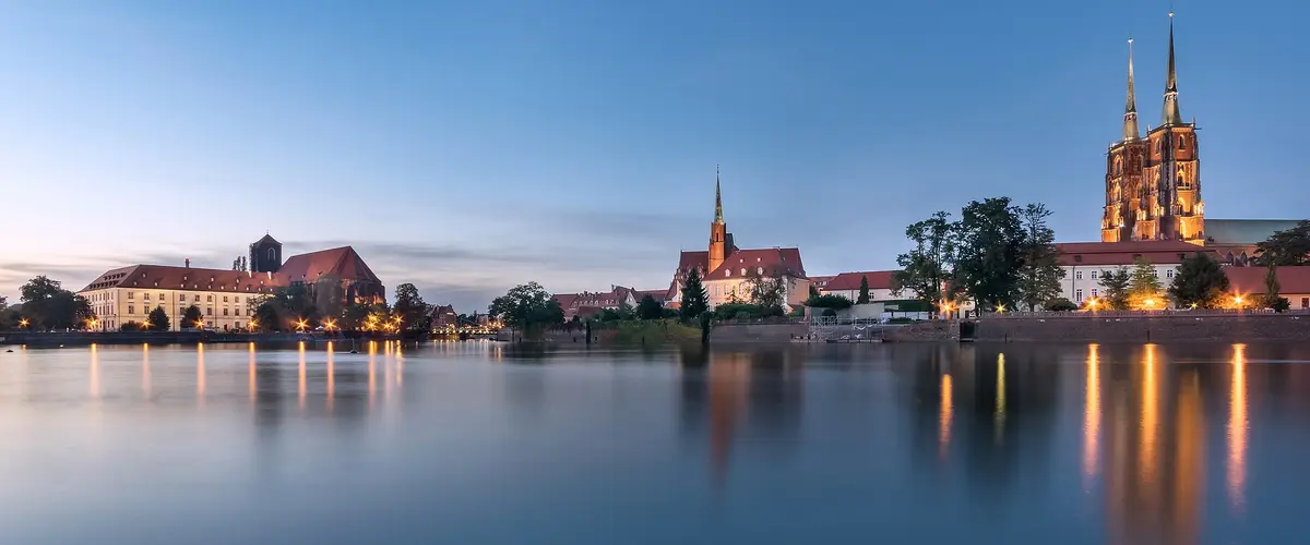 Ostrów Tumski we Wrocławiu nad Odrą o zmierzchu, wieże katedry odbite w wodzie